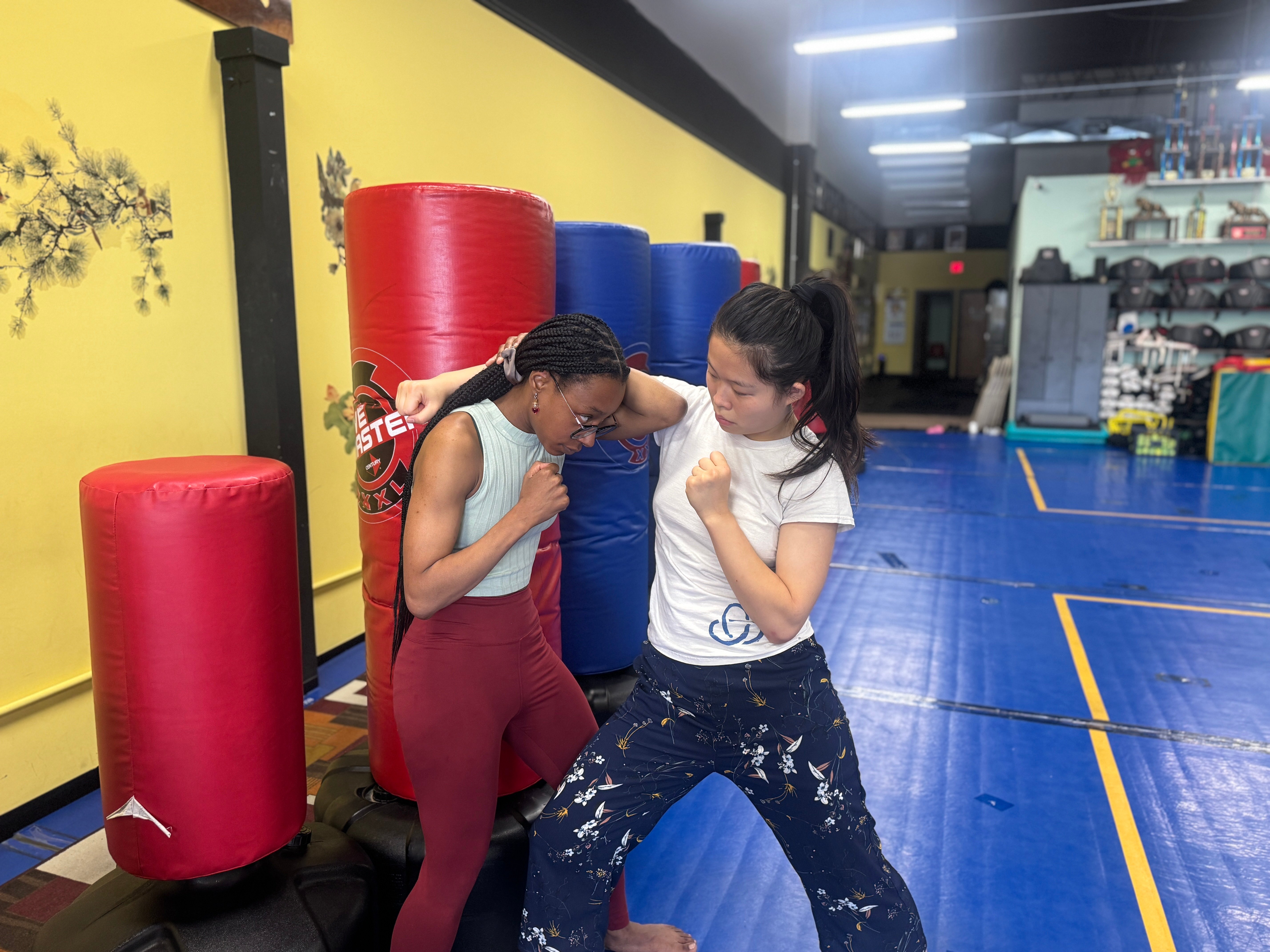 One student striking, the other putting her elbow up as a guard while pushing forward.